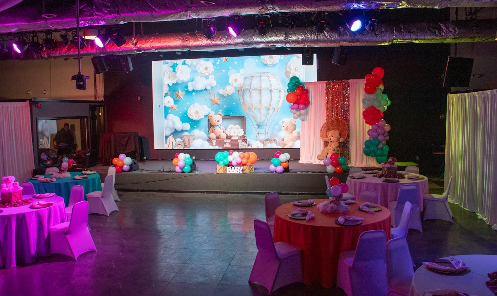 A decorated event stage and tables set for a celebration