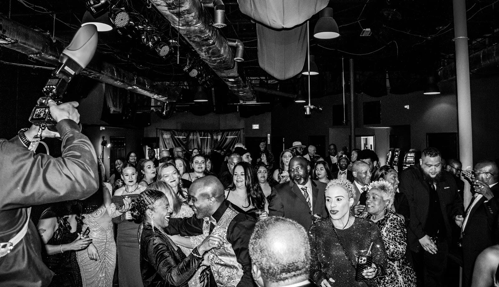 Black and white shot of guests celebrating at a casino-themed party