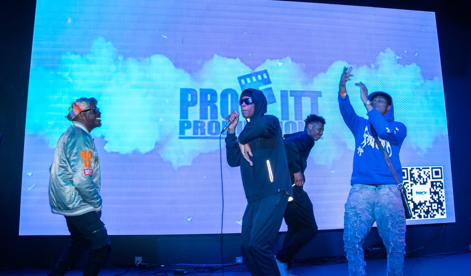 Hip-hop artists performing in front of a bright LED wall