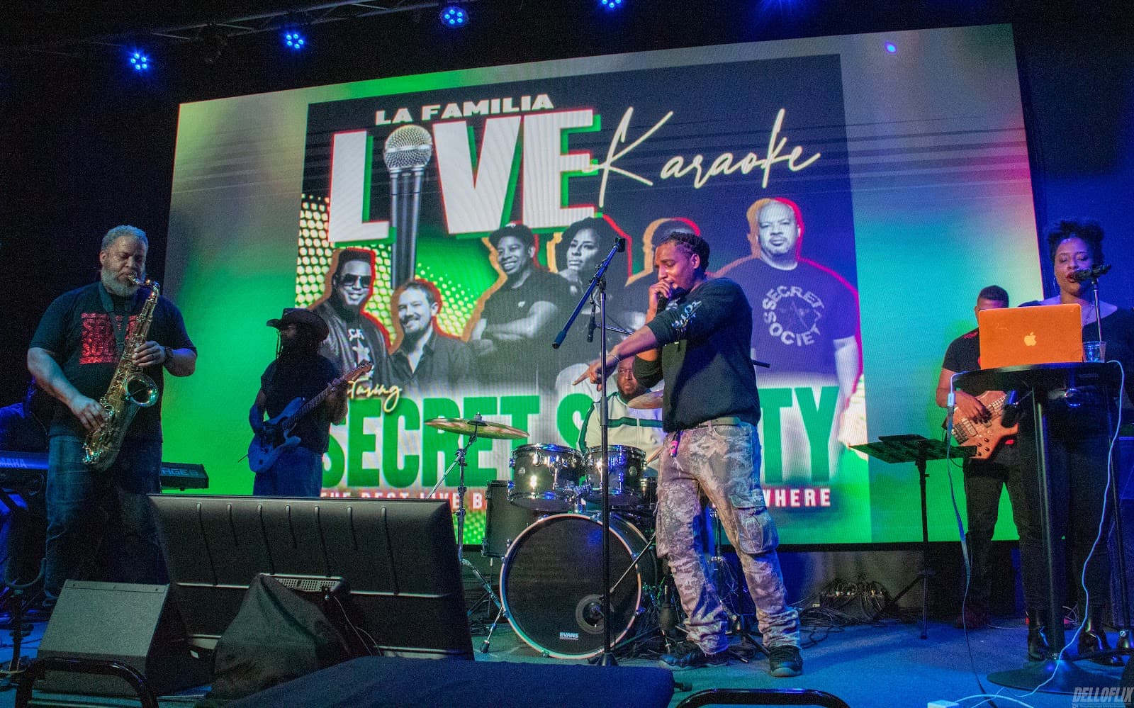 A live band performing under green and blue stage light