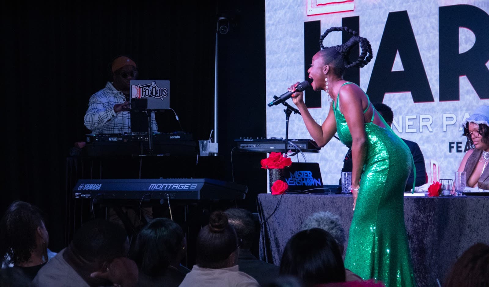 A singer in a green sequined dress performing at a dinner show
