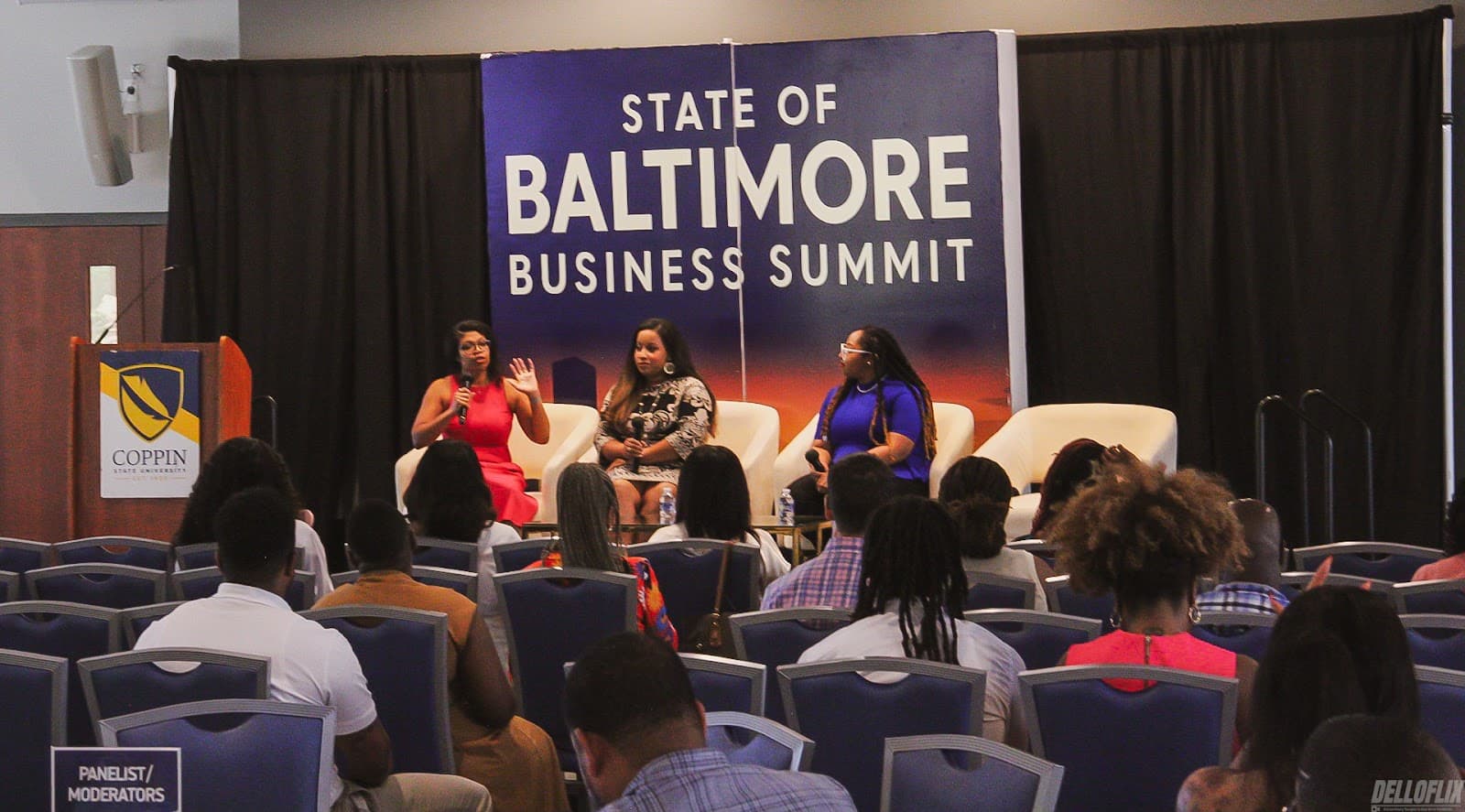 A full audience facing the stage at a business summit