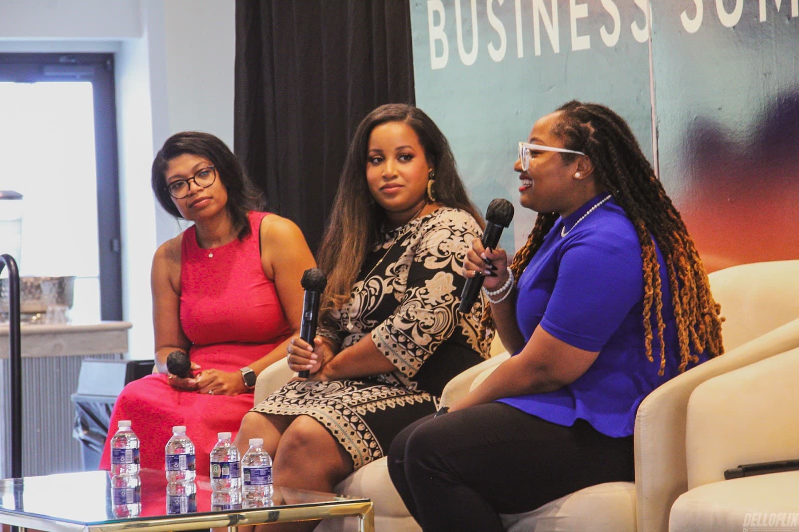 Three women speaking on a business summit panel