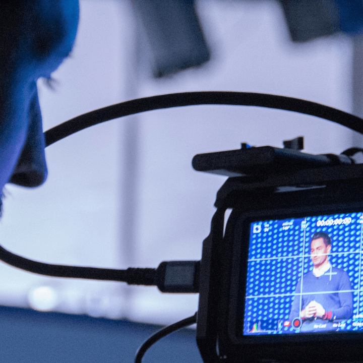 DelloFlix operator checking framing on a camera monitor during a speaker shoot