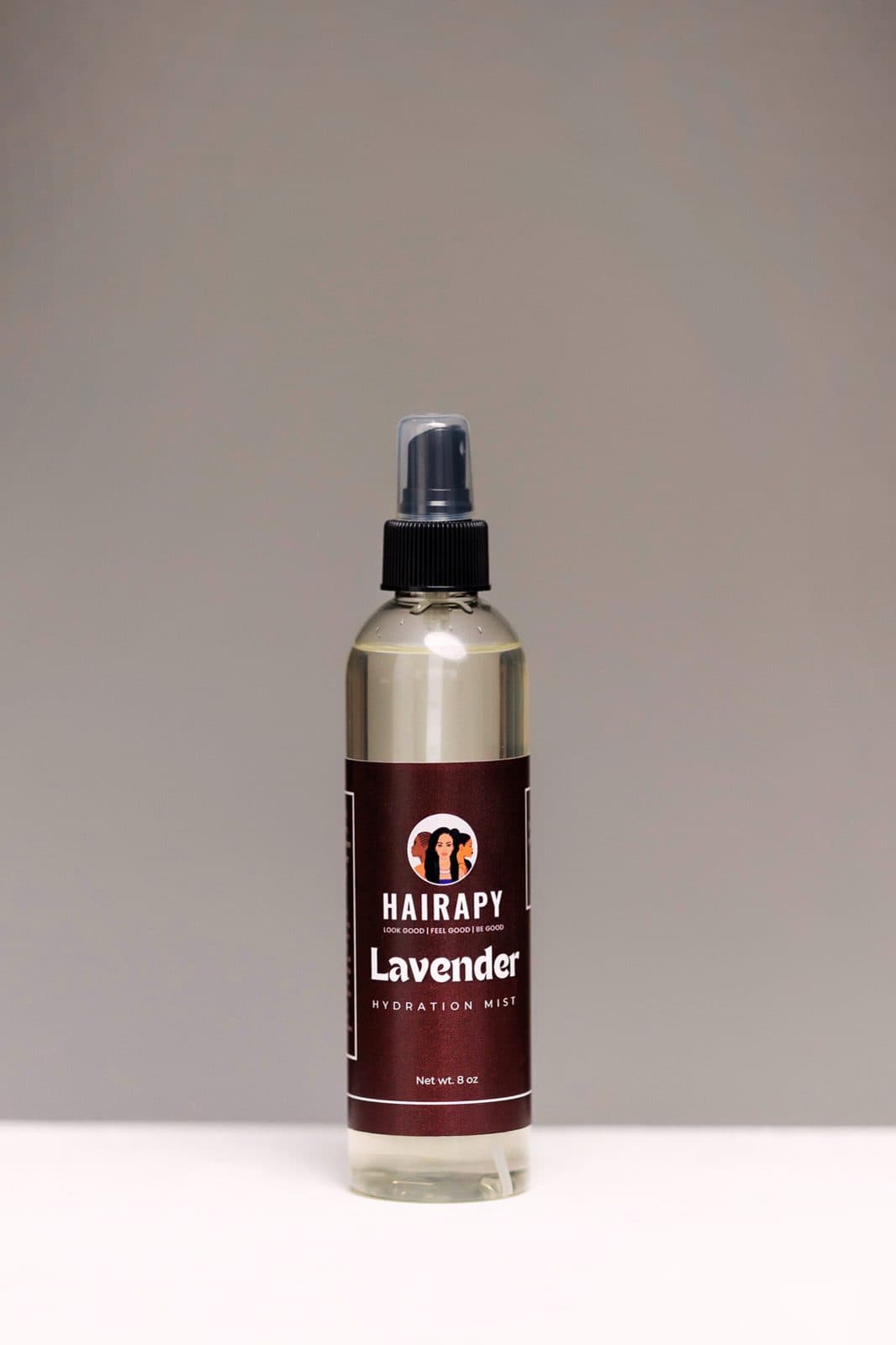 Hairapy lavender hydration mist bottle on a seamless backdrop